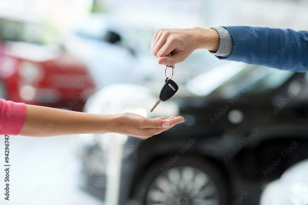 car dealer giving keys to woman