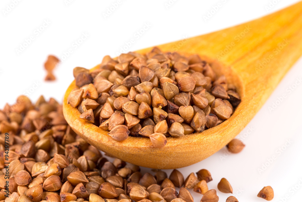 Uncooked buckwheat on wooden spoon Uncooked buckwheat on wooden spoon