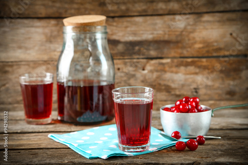 Sweet homemade cherry juice on table, on wooden background