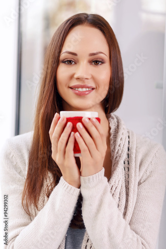 Attractive young lady with a cup of drink.