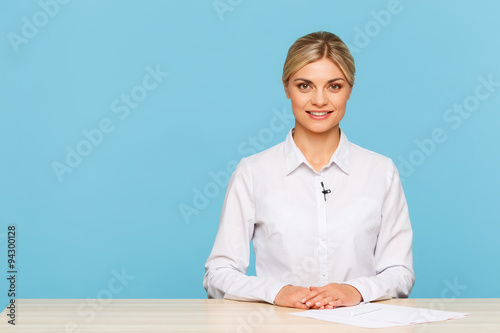 Pleasant TV announcer sitting at the table  photo