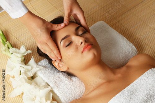 Young woman in beauty spa salon enjoying head massage