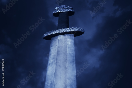 Medieval viking sword against a dramatic sky