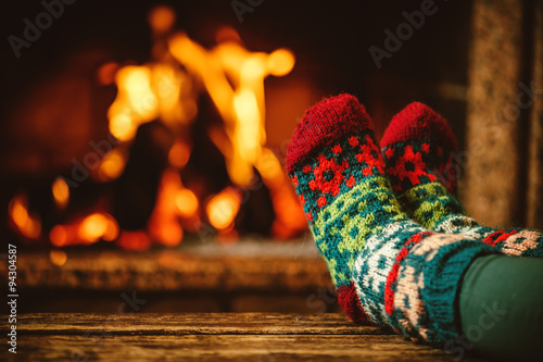 Foto Feet in woollen socks by the fireplace