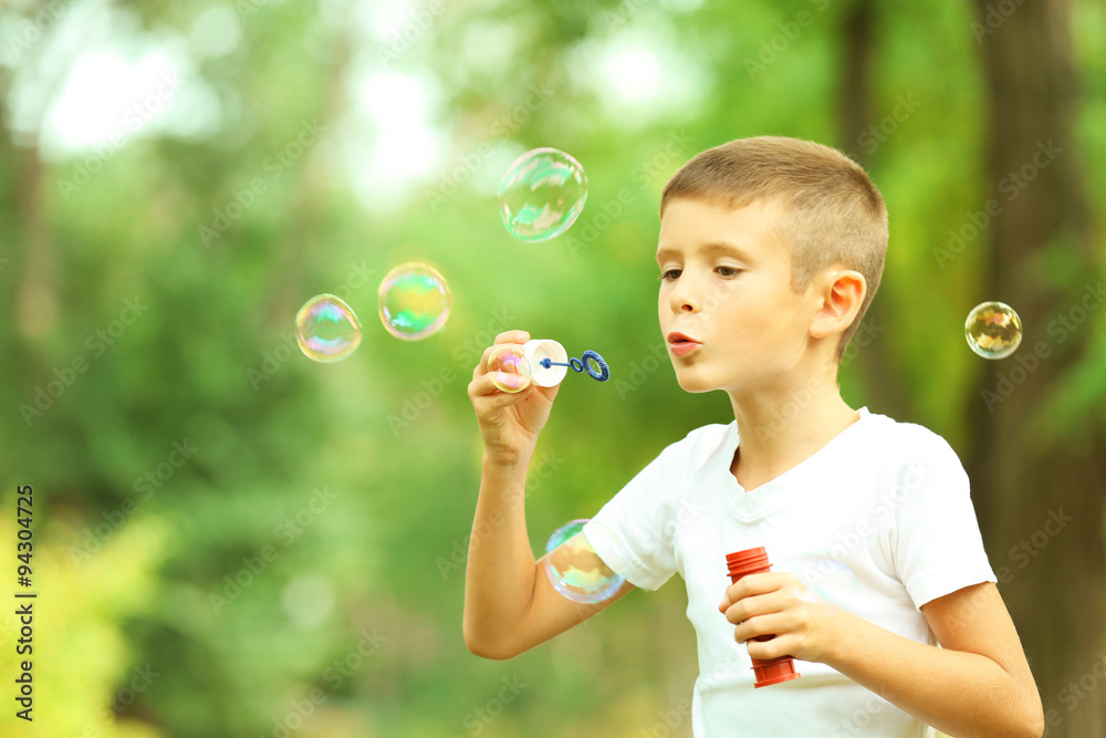 Little boy playing with bubbles in the park Little boy playing with bubbles in the park
