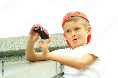 Little boy playing with toy car outside