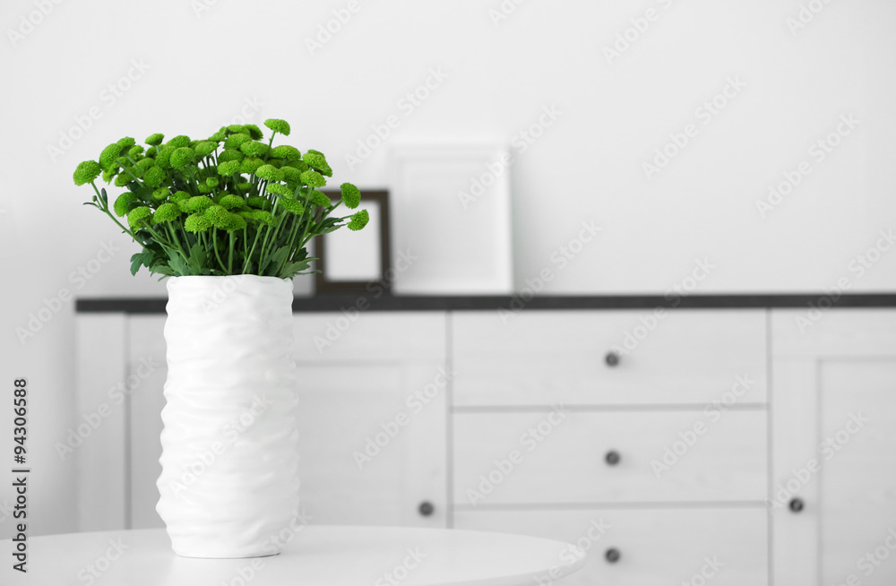 Beautiful green chrysanthemums in vase on table in room