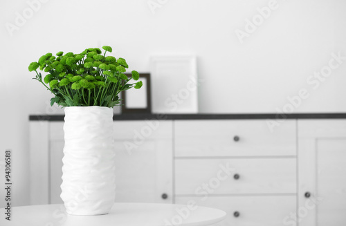 Beautiful green chrysanthemums in vase on table in room