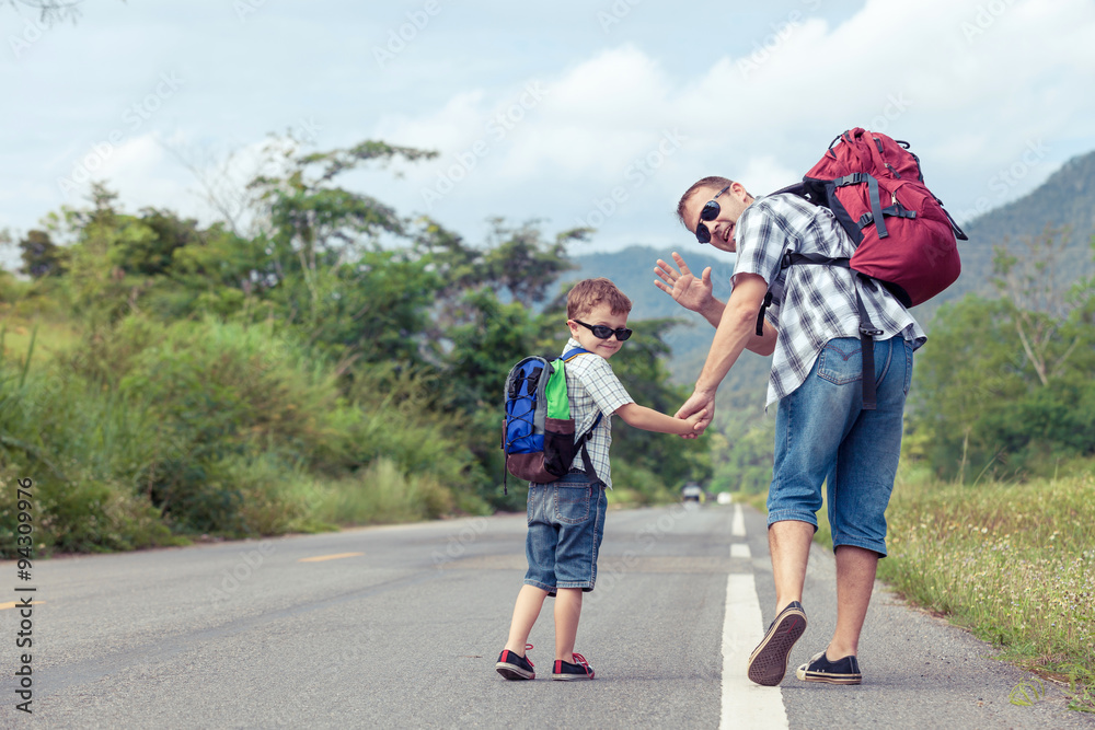 Father and son walking on the road.