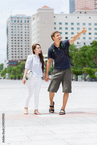 Couple asian girl and caucasian man tourist smile point finger