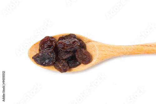 Raisin with wooden spoon isolated on white.