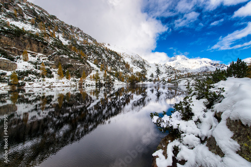 Mountains and alpine lake with snow fall