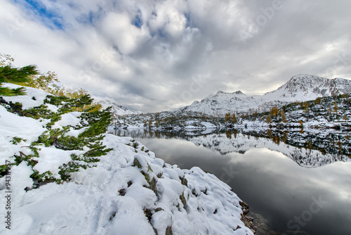 Walking beside Alpine lake with snow