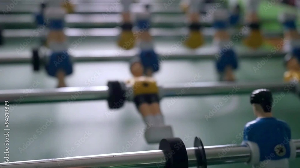 Table football game with yellow and blue players in slowmotion Table football game with yellow and blue players in slowmotion