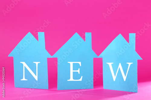 Color paper houses on pink background