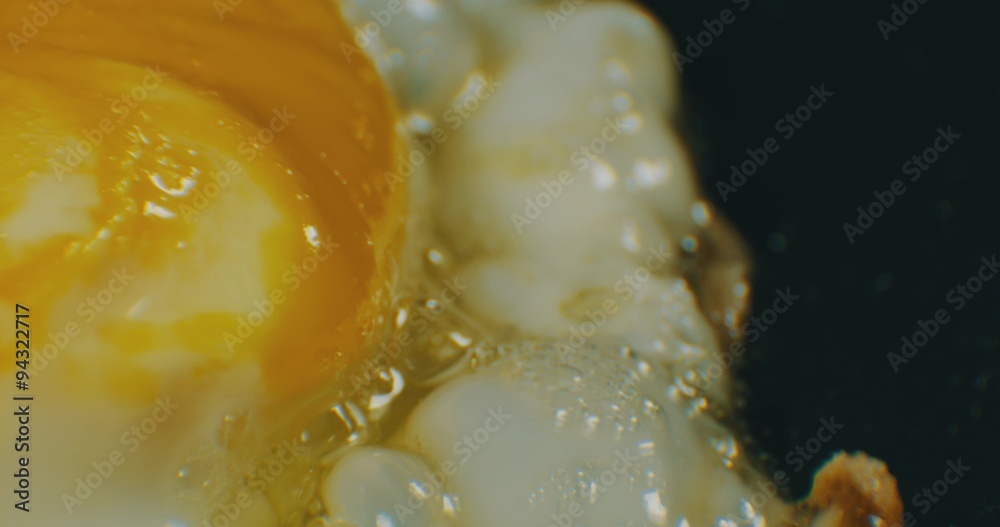 Extreme macro of greasy fried egg on frying pan. 4K Extreme macro of greasy fried egg on frying pan. 4K