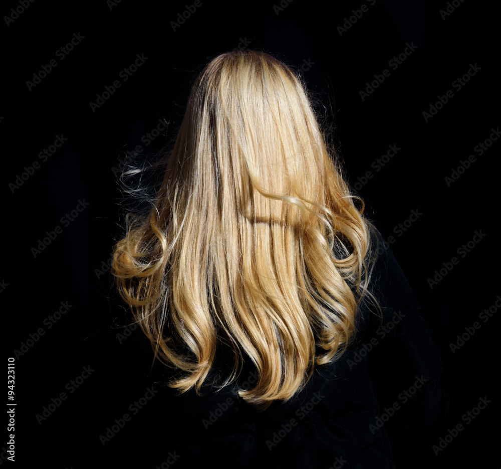 Naklejka premium Blonde woman walking on sidewalk. Only hair visible.