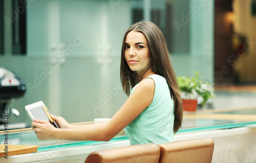 Free Download Beautiful young woman with digital tablet in cafe - GFXLoad