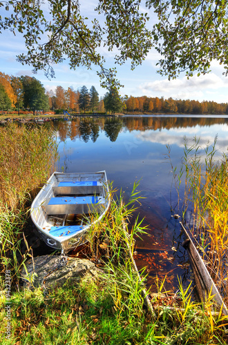 Vertical autumn landscape with aluminium boat