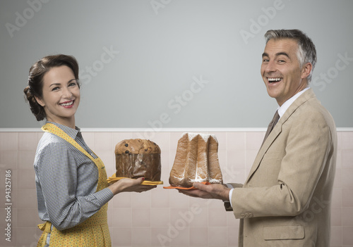 Smiling couple at home with christmas cakes