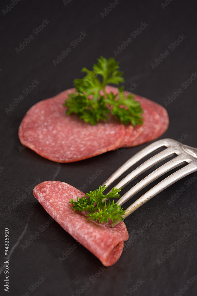 Salami auf einer schwarzen Platte