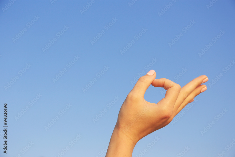 Woman hand on blue sky background Woman hand on blue sky background
