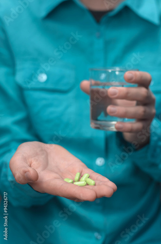 pills and a glass of water in her hand