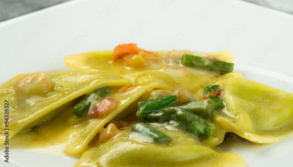 Ravioli di pesce con asparagi e gamberetti, piatto in primo piano Ravioli di pesce con asparagi e gamberetti, piatto in primo piano