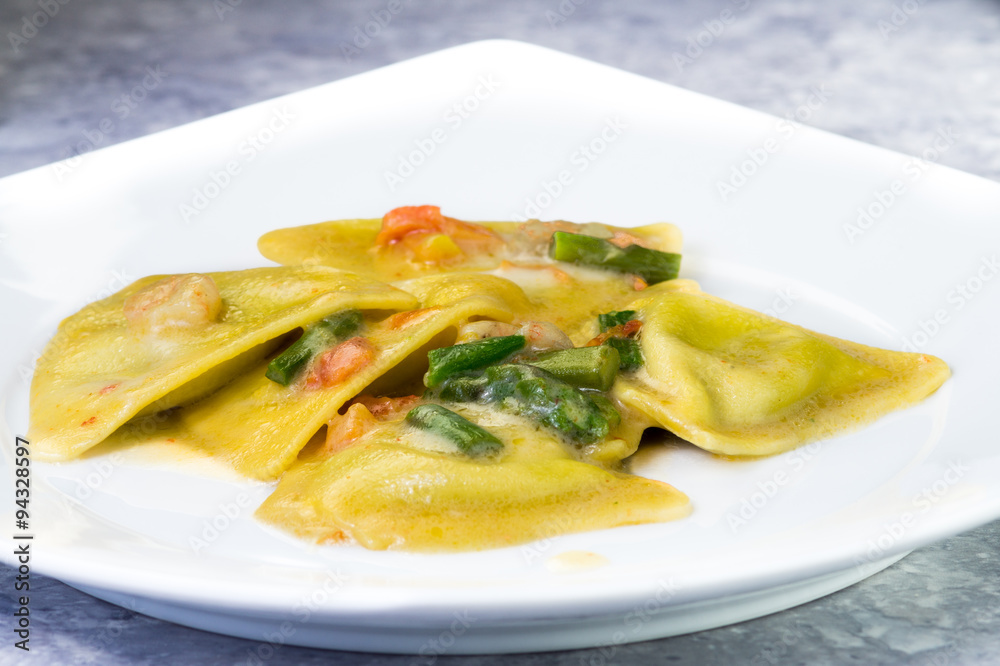Ravioli di pesce con asparagi e gamberetti, piatto in primo piano Ravioli di pesce con asparagi e gamberetti, piatto in primo piano