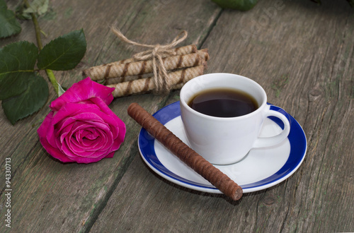 cup of coffee, one rose, linking of cookies on a wooden table, a