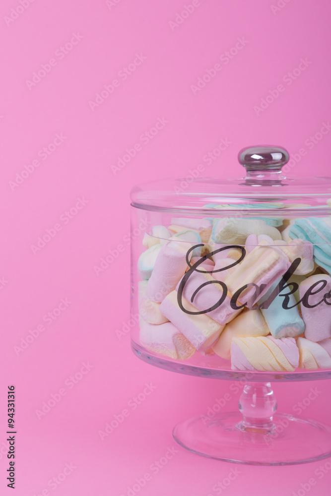 marshmallow candies of different colors in the glass on the background of pink. top view. entertainment for children in celebration. marshmallow candies of different colors in the glass on the background of pink. top view. entertainment for children in celebration.