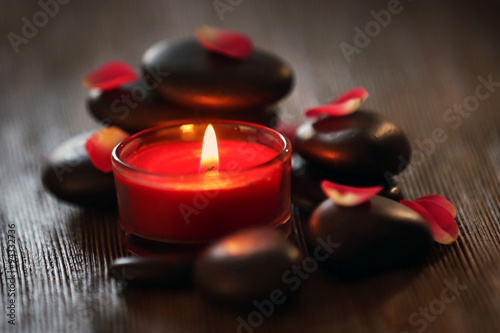 Spa stones and candles on dark background