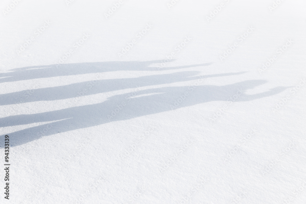 Drei Schatten im Schnee winken