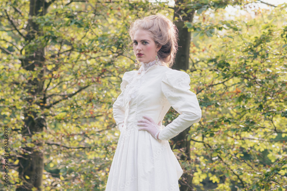 Retro victorian fashion woman in front of trees.