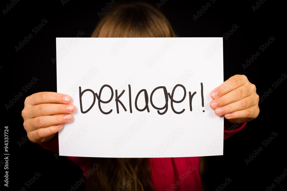 Child holding sign with Norwegian word Beklager - Sorry