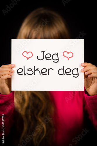 Child holding sign with Norwegian words Jeg Elsker Dig - I Love photo