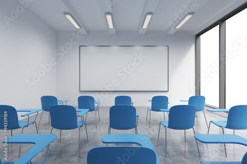 A classroom or presentation room in a modern university or fancy office. Blue chairs, a whiteboard on the wall and panoramic windows with white copy space. 3D rendering. photo