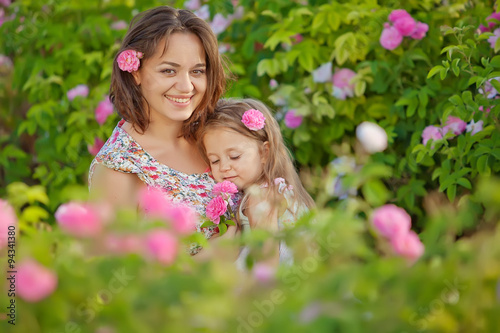 Happy mother with her kid in roses 