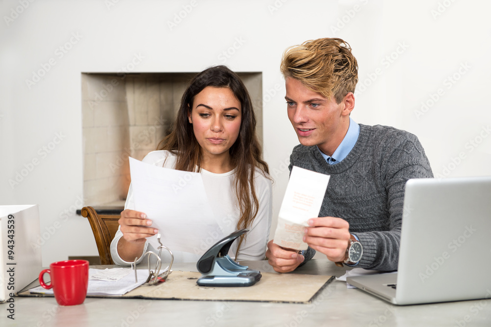 Man and woman at a kitchen table, sorting out their personal fin - obrazy, fototapety, plakaty 