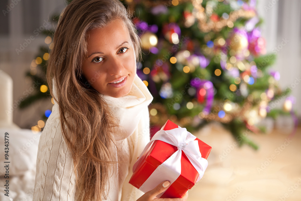 Young woman relaxing on chair in front of Christmas tree Young woman relaxing on chair in front of Christmas tree