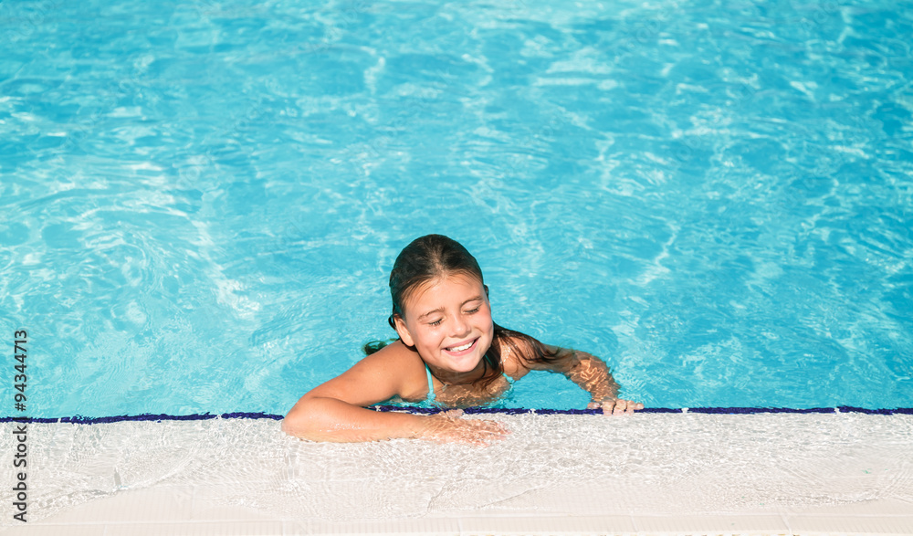 cute charming  little girl relaxing in swimming pool with closed eyes