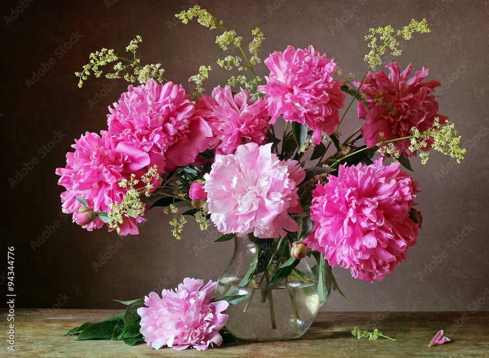 Bouquet of pink peonies in a transparent jug.