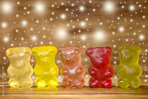 multicolored gummy bear and glitter on wood