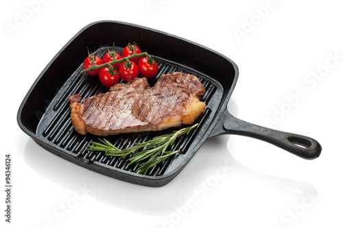 Sirloin steak with rosemary and cherry tomatoes cooking in a fry