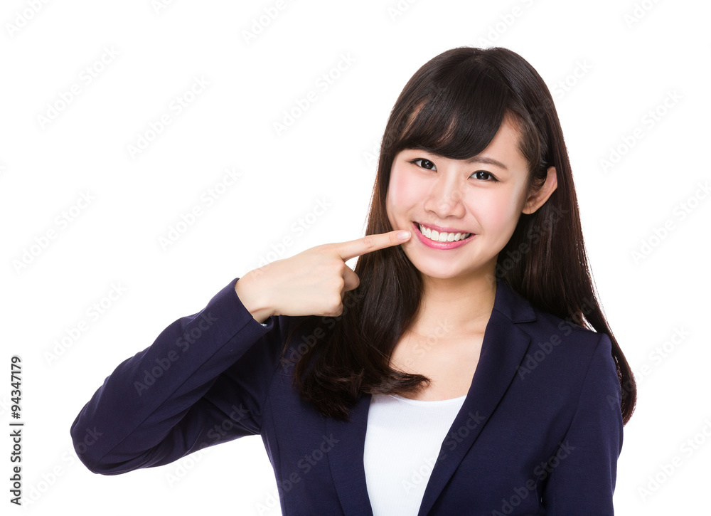 Businesswoman with finger point to her teeth Businesswoman with finger point to her teeth