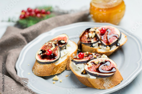 Fig toast with walnuts and balscamic glase on plate. Christmas appetizer