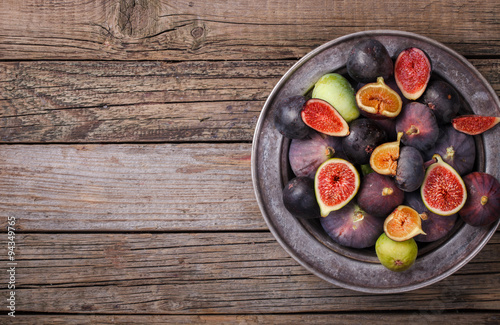 Fresh figs in different grade, in a vintage metal plate on a wooden Board.Copy space.selective focus