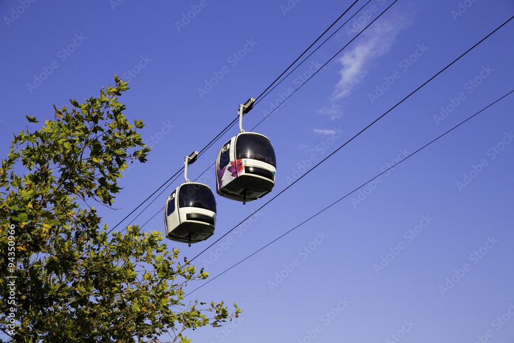 Two cable cars in motion in the air with blue sky background Two cable cars in motion in the air with blue sky background