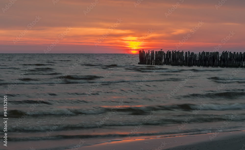 Naklejka premium Wooden broken marine pier at dawn, Baltic Sea 