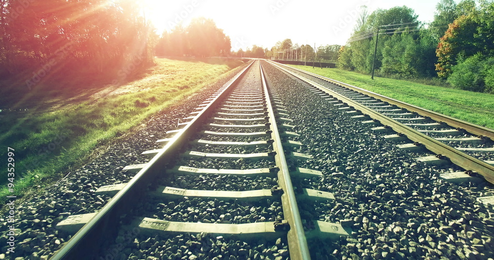 AERIAL. Camera flight from train tracks to the high summer sunset sky